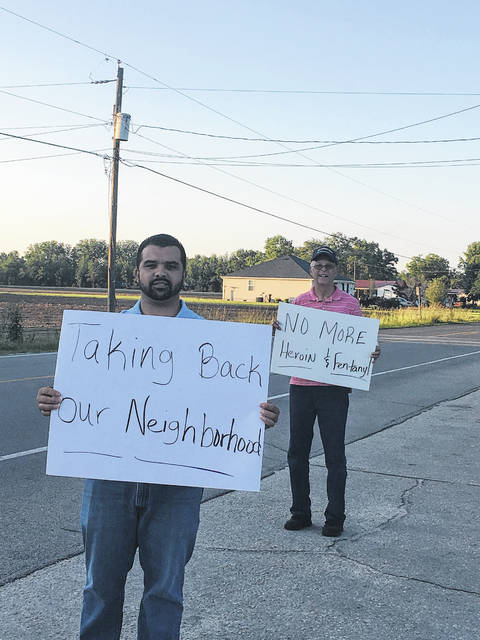 
			
				                                Protesters Jeffrey Locklear, left, and Virgil Lowry hold signs Saturday during a protest of drug activity in the Union Chapel community in Pembroke.
 
			
		