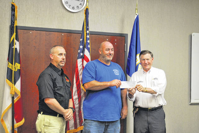
			
				                                Pine Terrace Volunteer Fire Department Assistant Fire Chief George McEwen, middle, receives a $5,000 grant Monday from North Carolina Insurance Commissioner and State Fire Marshal Mike Causey as Chief State Fire Marshal Brian Taylor looks on. The money is a part of a $500,000 Blue Cross Blue Shield grant awarded to volunteer fire departments across the state.
 
			
		