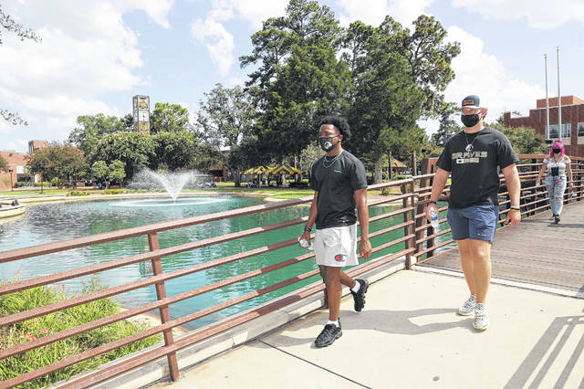 
			
				                                Students wearing masks walk across the bridge at the on-campus water feature at The University of North Carolina at Pembroke during the Brave Walk two weeks ago. The university has reported that 34 students have tested positive for COVID-19 since returning to campus, and nine of them have recovered.
                                 UNCP | Courtesy Photo

			
		