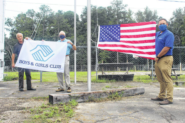 
			
				                                Lumberton Boys and Girls Club Director Ron Ross, left, and Mountaire Farms Community Relations managers Mark Reif and Jarrod Lowery prepare to raise two of the three flags recently donated by the poultry company. The company provided an American, a North Carolina and a Boys and Girls Club flag.
                                 Tomeka Sinclair | The Robesonian

			
		