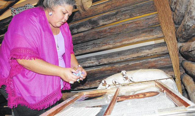  Museum educator Alisha Monroe configures family portraits and cotton on an old window to represent the importance of agriculture. The finished product will be one of a 10-piece collection she hopes to show in the summer. Tomeka Sinclair | The Robesonian 