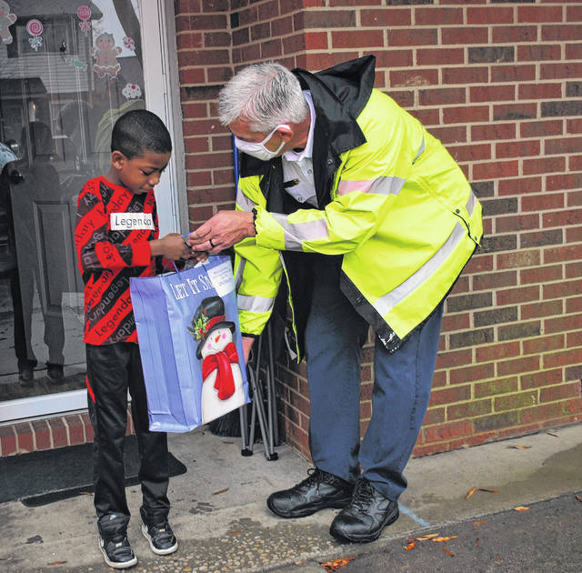 
			
				                                Willis Campbell, left, receives a gift Thursday from Lumberton City Fire Battalion Chief McGregor Strickland during the department’s delivery of toys collected as part of its annual toy drive. Toys were delivered to about 50 families in Lumberton.
 
			
		