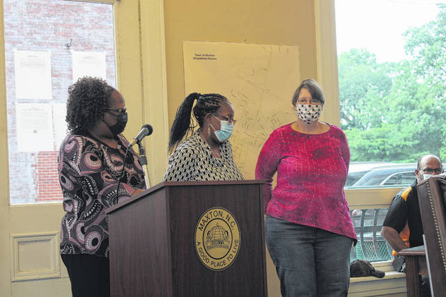 
			
				                                Maxton Town Manager Angela Pitchford, left, introduces the town’s recently hired billing clerks: Annie Baker and Leslie Maynard. Baker started in April and Maynard in July.
                                 Tomeka Sinclair | The Robesonian

			
		