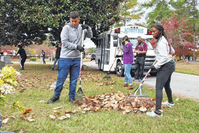 
			
				                                Lumberton High Junior Reserve Officers’ Training Corps Cadet SFC Kylan Locklear works Thursday with Cadet Major Brianna Richardson and others to help clear an area of leaves at Meadowbrook Cemetery in Lumberton, as part of the LHS JROTC service project which includes the cleaning of multiple cemeteries.
 
			
		