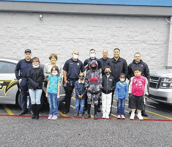 
			
				                                Fairmont Chief of Police Jon Edwards, third from right on the back row, stands Saturday with police officers and children at the Walmart Supercenter in Pembroke The children were all served as part of the Shop with a Cop program which provided funding to take them shopping. The holiday program seeks to serve community children in need by providing them gifts for Christmas.
                                Courtesy photo | Fairmont Police Department
 
			
		