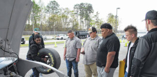 
			
				                                Some Career and Technical Education students stand by and keep time Wednesday as a student changes a tire on a racecar at the Career Center Expo Event held at the Southeastern Agricultural Center.
 
			
		