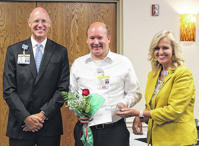 
			
				                                UNC Health Southeastern President/CEO Chris Ellington, left, and VP/Chief Nurse Executive Renae Taylor present the 2022 Baker Nurse of Excellence Award to registered nurse Christopher Minton on Tuesday during a Nurses Week ceremony in the UNC Health Southeastern Cafeteria.
                                 Courtesy photo | UNC Health Southeastern

			
		