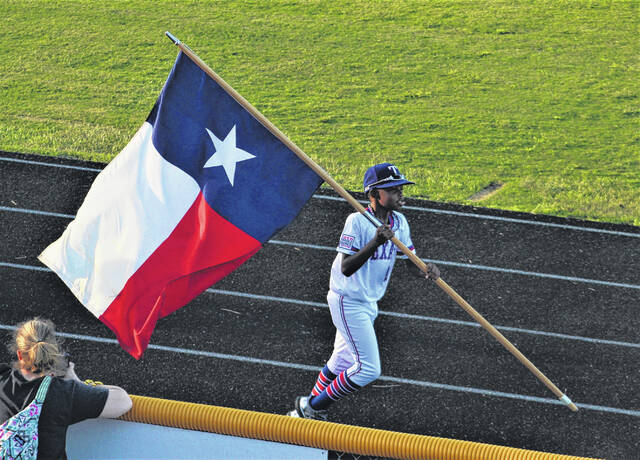 
			
				                                Jacob Walton from the Texas AAA team carries the Texas state flag during the Dixie Youth World Series opening ceremony Friday at Alton G. Brooks Stadium in Lumberton. For more photos, see page 1A and 1B.
                                 Chris Stiles | The Robesonian

			
		