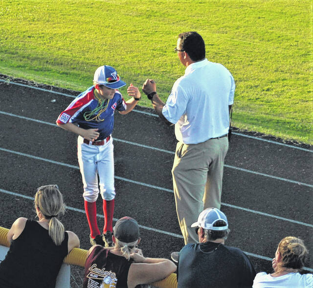 <p>Landon Smith from the Virginia majors team fist bumps Lumberton Youth Baseball Association president Tim Locklear during the Dixie Youth World Series opening ceremony Friday at Alton G. Brooks Stadium in Lumberton.</p>
                                 <p>Chris Stiles | The Robesonian</p>