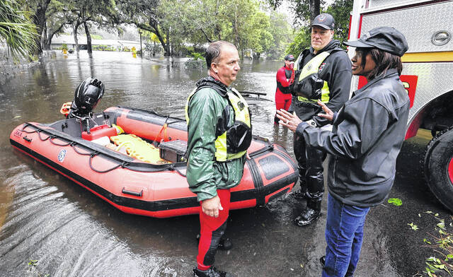 Congresswoman Val Demings, D-Orlando, talks to first responders during the rescuing of residents trapped by floodwaters in the Orlo Vista neighborhood in Orlando, Fla., caused by heavy rains from Hurricane Ian on Thursday.
                                 Joe Burbank | Orlando Sentinel via AP