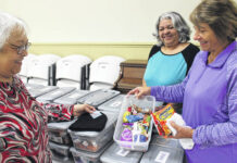 
			
				                                Patricia Hagans, right, Vanessa Jacobs and Suzanne Locklear, of the Burnt Swamp Baptist Association’s Women’s Missionary Union show the contents of care packages that will be distributed to students staying on The University of North Carolina at Pembroke campus during the holidays.
 
			
		