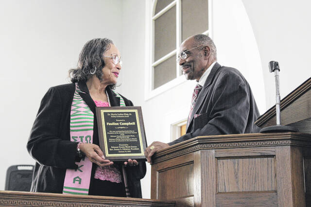 <p>Robeson County Black Caucus President Jimmy Gilchrist awards Robeson County Commissioner Pauline Campbell with the Martin Luther King Jr. holiday award during a celebration held Monday at Bethany Presbyterian Church in Lumberton.</p>