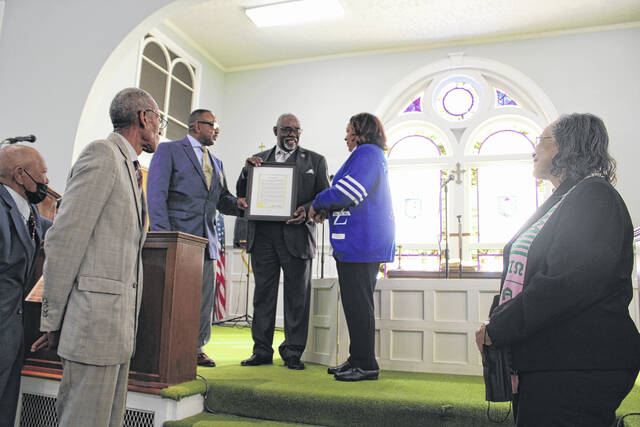 <p>Robeson County elected officials past and present stand alongside The Rev. Ricky Banks, who was presented with a proclamation on behalf of the Lumberton City Council, after speaker during the Martin Luther King Jr. Celebration.</p>
