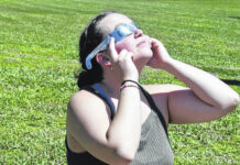 
			
				                                Kellie Watts takes a look at the eclipse of the sun on a perfect day at Robeson Community College Monday.
                                 David Kennard | The Robesonian

			
		