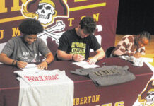 
			
				                                Lumberton wrestlers Wyntergale Oxendine, left, Jackson Buck, center, and Janya Rolland, right, sign collegiately during a ceremony Thursday at Lumberton. Oxendine signed to Indian Hills Community College, Buck to UNC Pembroke and Rolland to Allen.
                                 Chris Stiles | The Robesonian

			
		