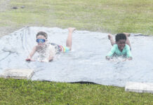 
			
				                                Two campers run a sliding drill on a slip ‘n’ slide at Lumberton High School’s youth baseball camp Thursday in Lumberton.
                                 Chris Stiles | The Robesonian

			
		