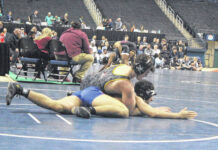 
			
				                                Two Lumberton wrestlers simultaneously competed for a state championship on Feb. 17 in Greensboro. In the foreground, Jackson Buck wrestles against Athens Drive’s Zaid Marjan in the 190-pound 4A boys title match; in the background, Wyntergale Oxendine wrestles against Havelock’s Nyema George in the girls 235-pound bout.
                                 Chris Stiles | The Robesonian

			
		